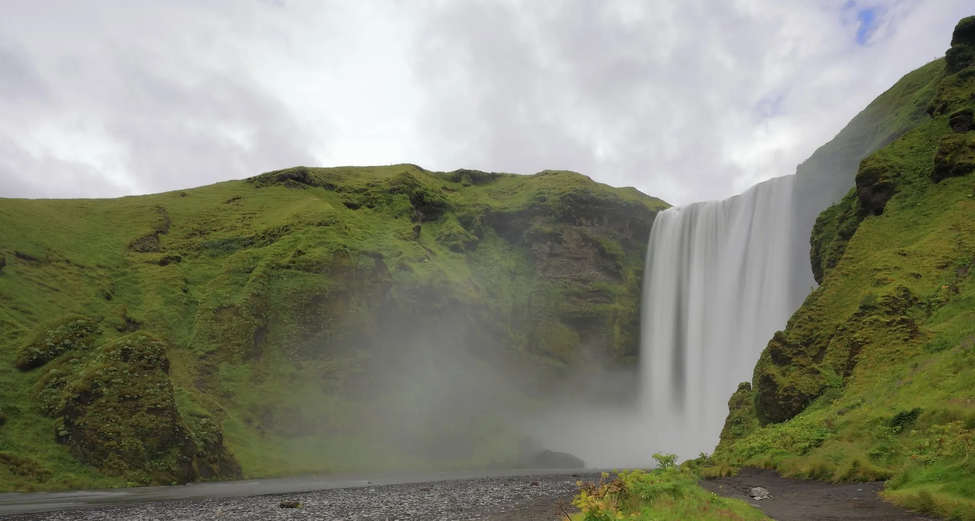Skógafoss, a wide 60-metre curtain of water plunging over a green cliff on Iceland's South Coast