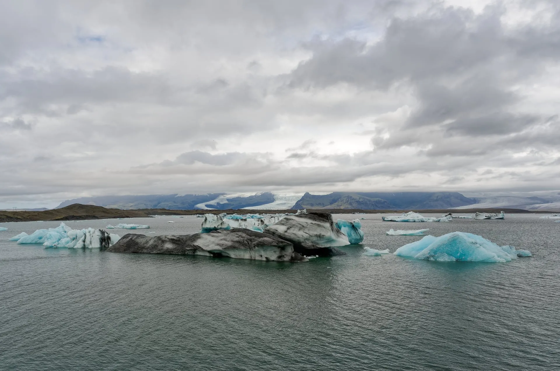 Blue icebergs drifting across the Jökulsárlón glacier lagoon beneath Vatnajökull in Southeast Iceland