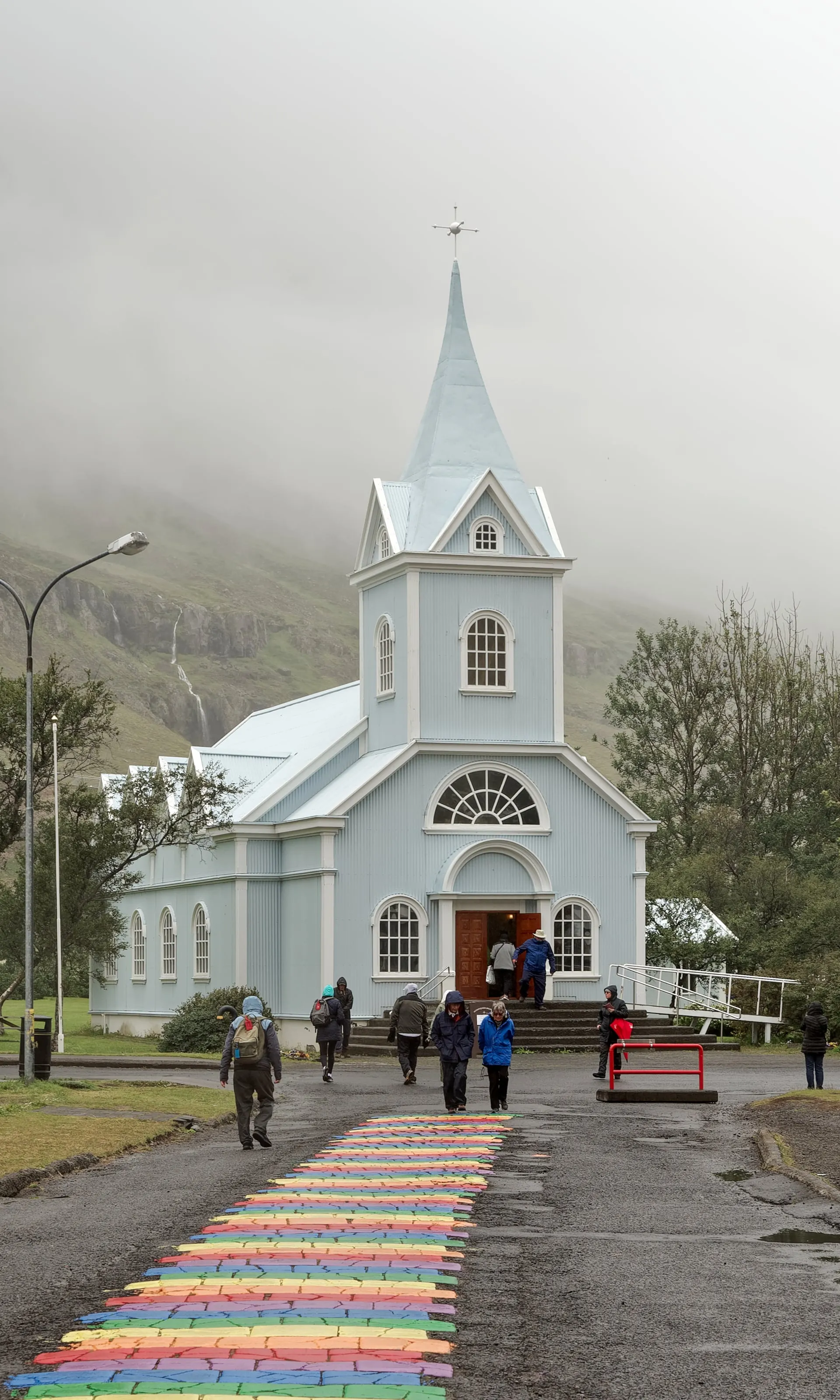 The blue church of Seyðisfjörður at the end of the rainbow-painted street, a landmark of East Iceland