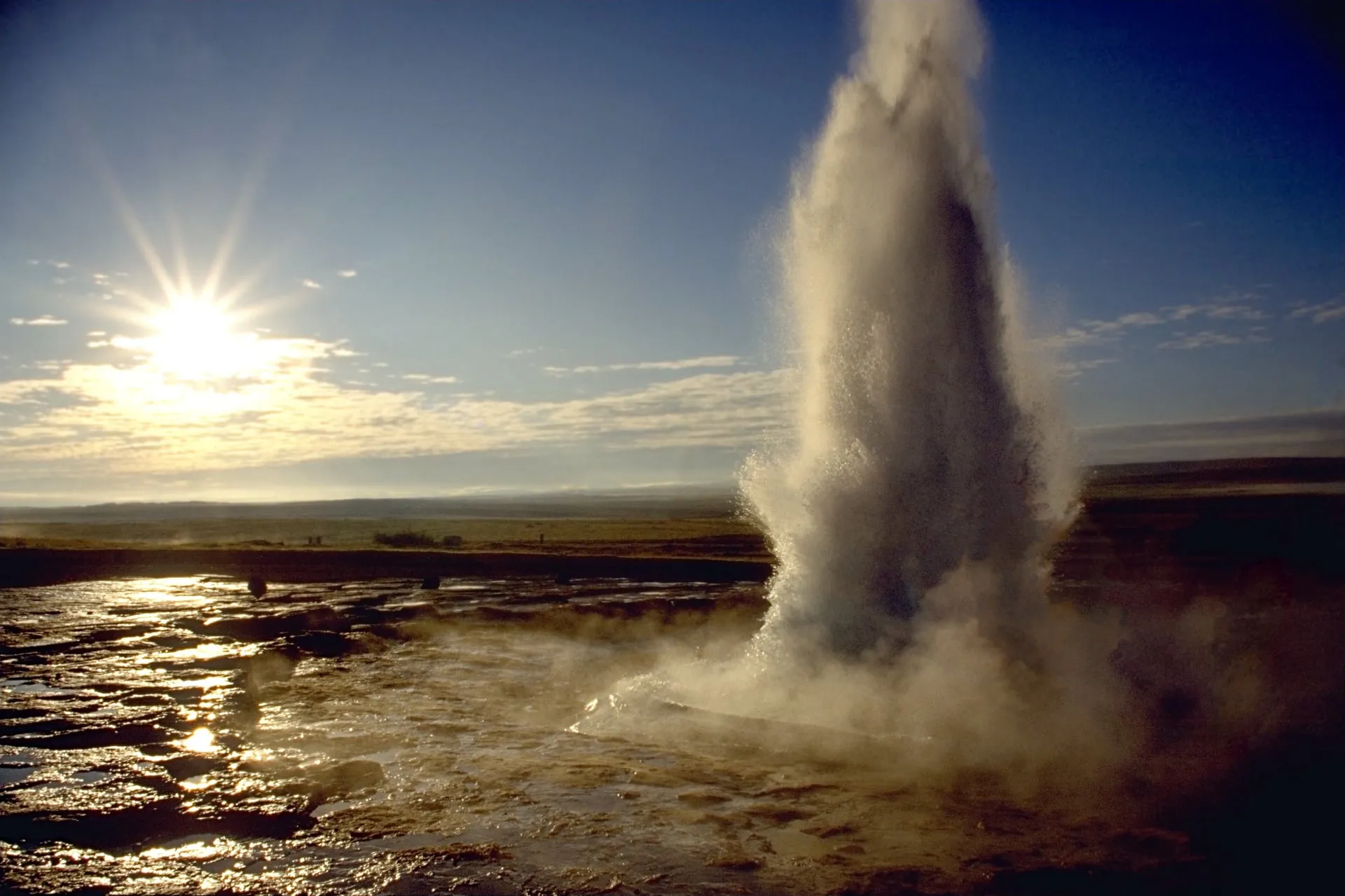The Strokkur geyser erupting against a blue sky in the Geysir geothermal area of South Iceland