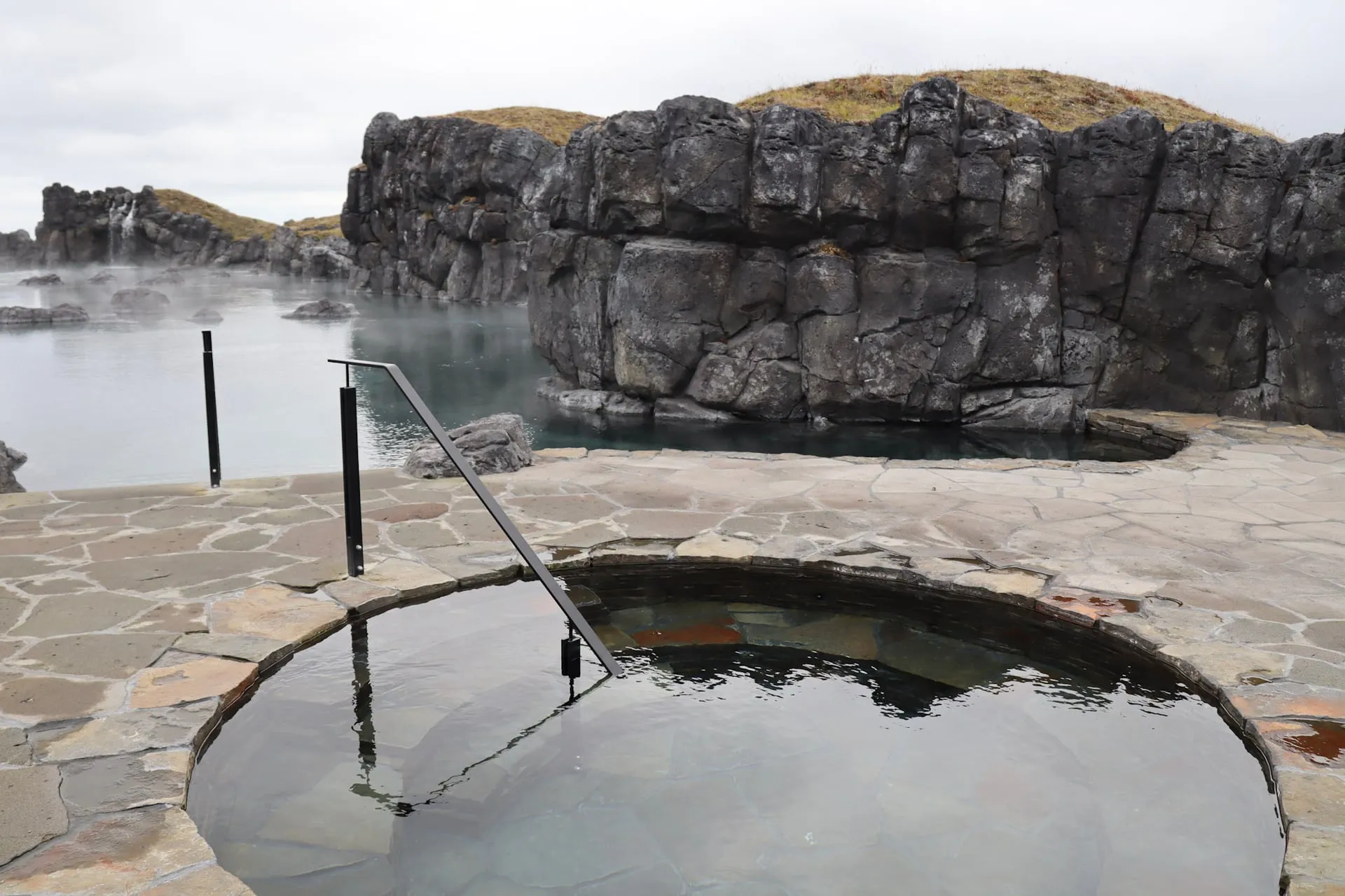 A bather steps into the cold-plunge pool beside the Sky Lagoon geothermal spa in Iceland
