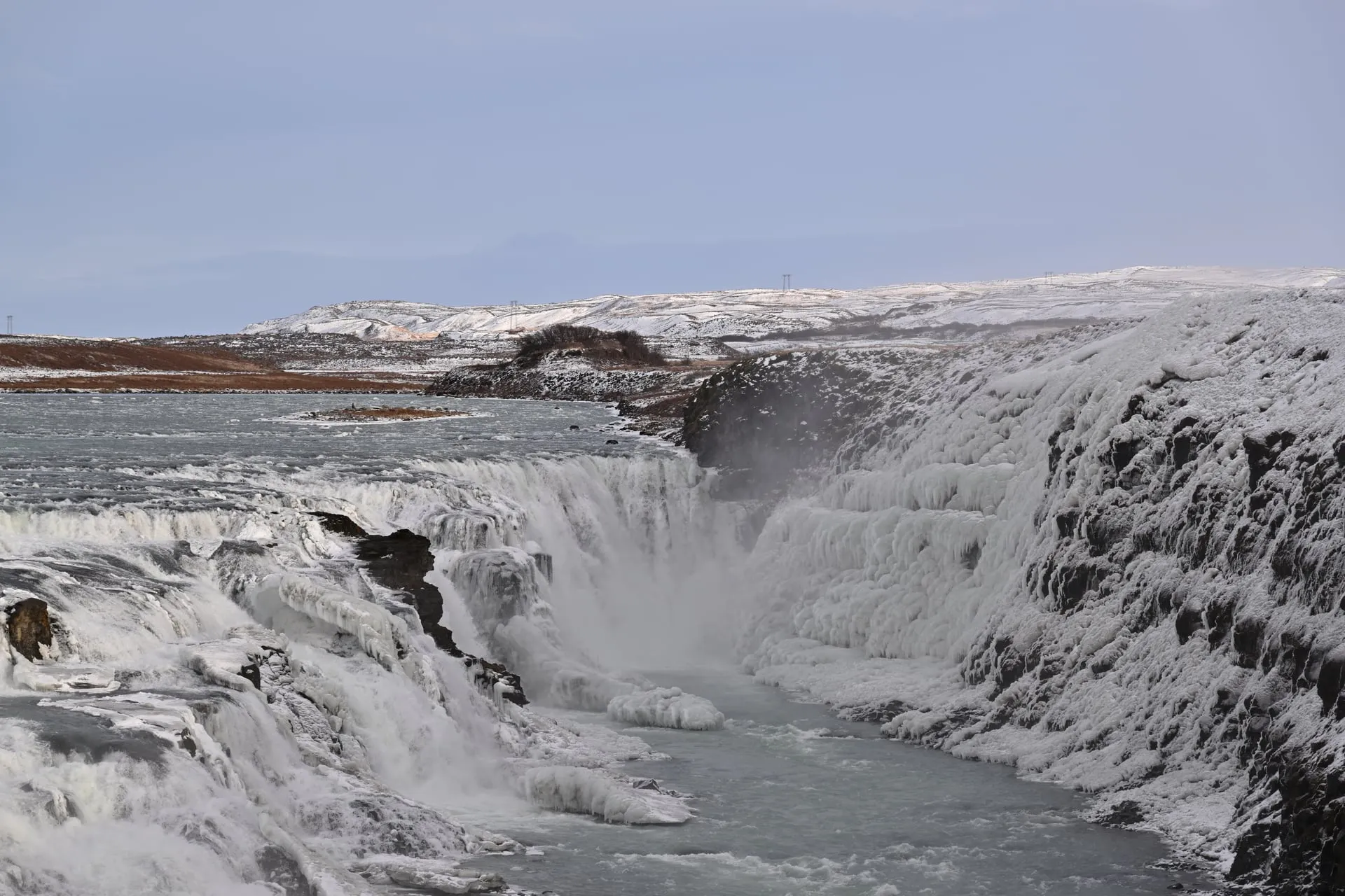 The Gullfoss waterfall on the Golden Circle framed by snow and ice on a clear February morning