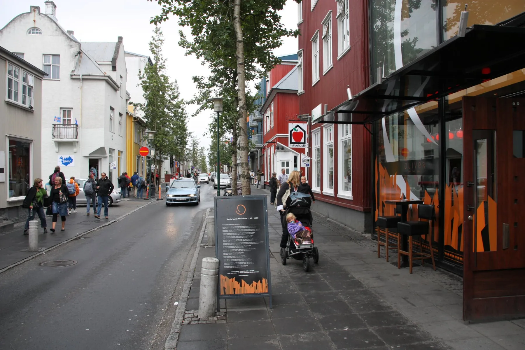 Pedestrians on Laugavegur, the main shopping street in central Reykjavík, lined with shops and cafés on a bright day