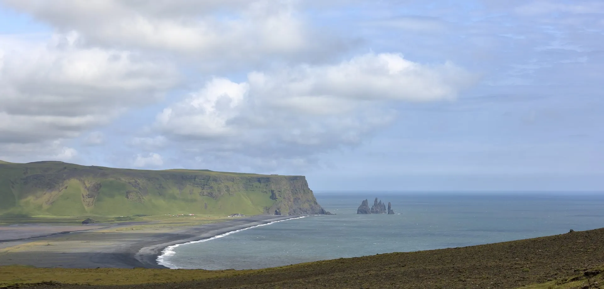 The Reynisfjara black-sand beach with the Reynisdrangar sea stacks rising from the ocean