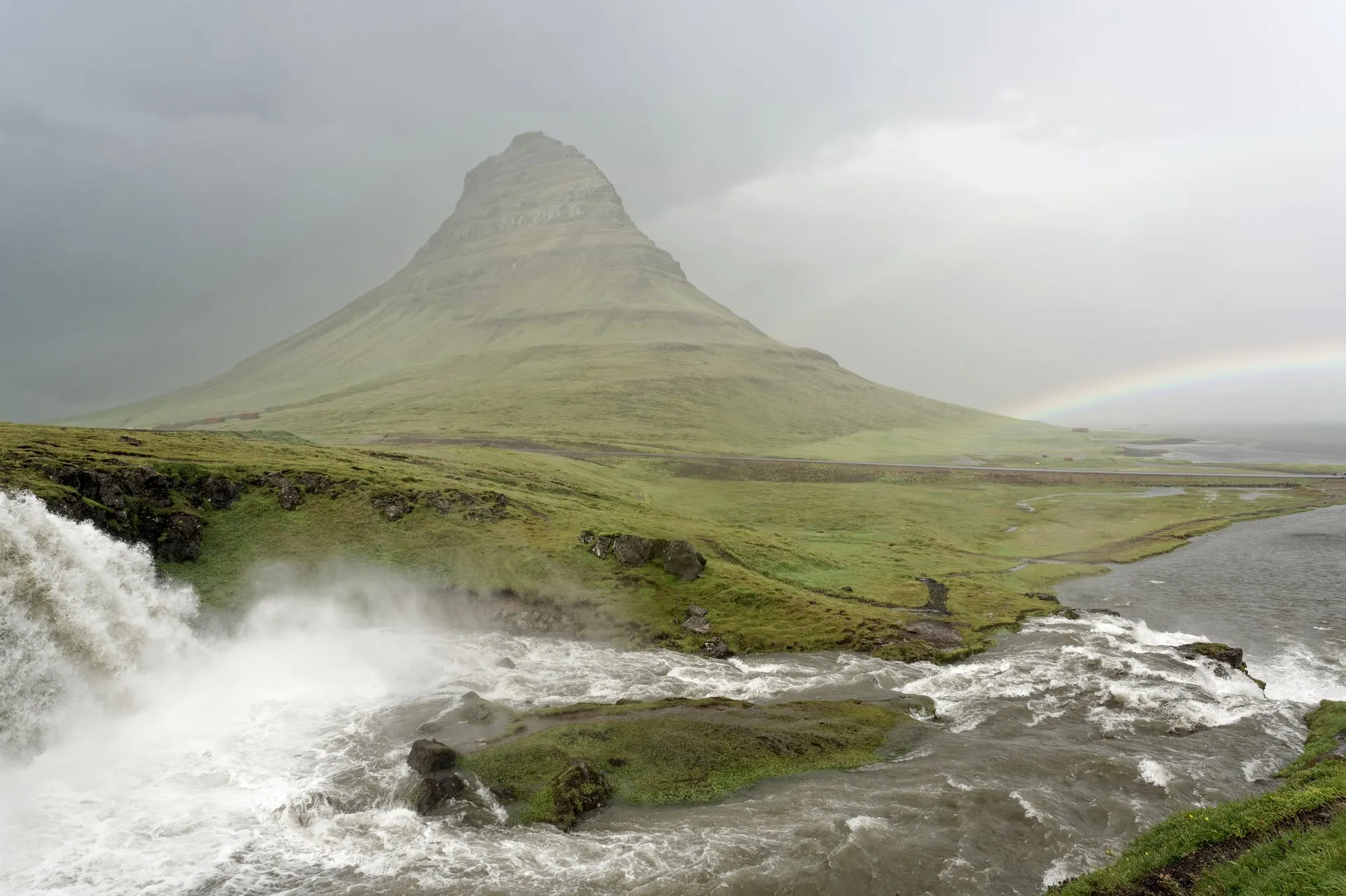 The distinctive cone of Kirkjufell mountain with the Kirkjufellsfoss waterfall in the foreground on the Snæfellsnes peninsula in Iceland
