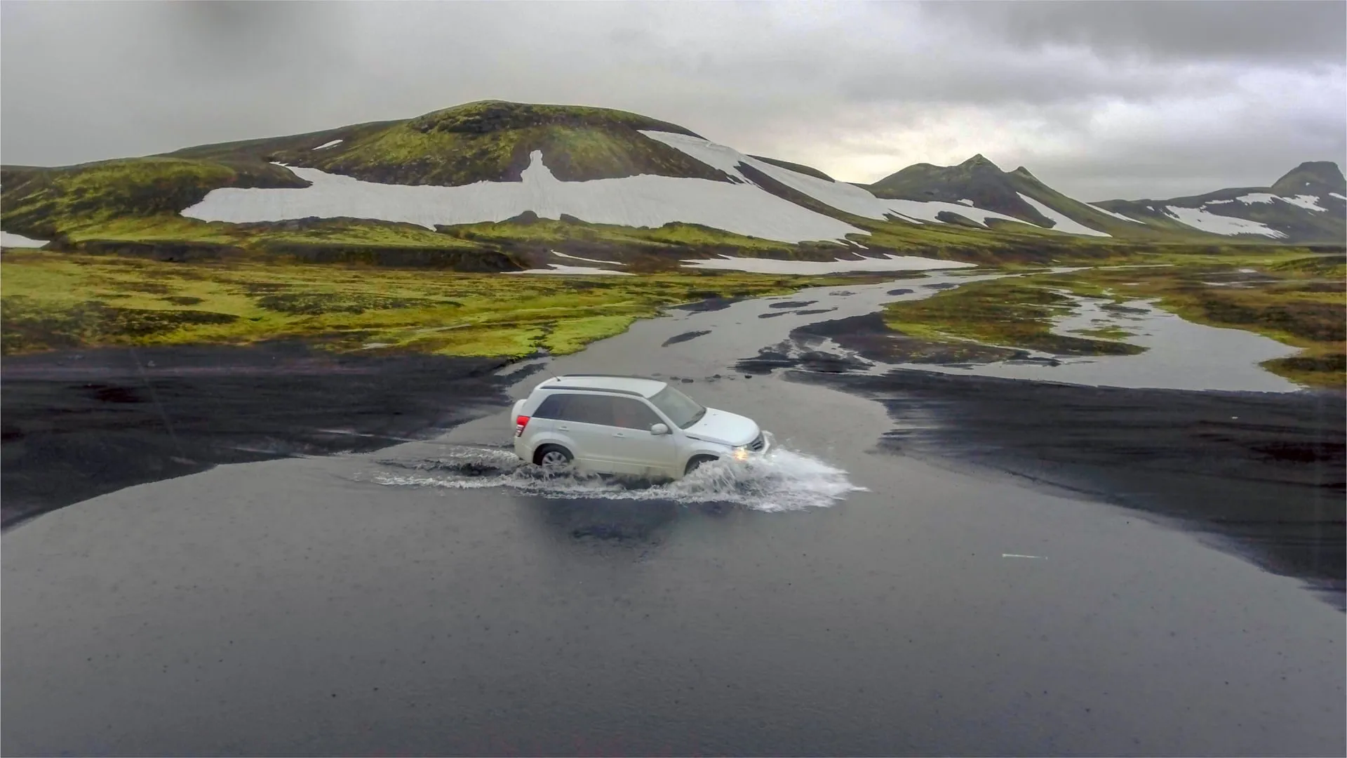 A 4x4 vehicle fording a glacial river on the unpaved F208 Fjallabaksleið nyrðri Highland mountain road in Iceland's interior